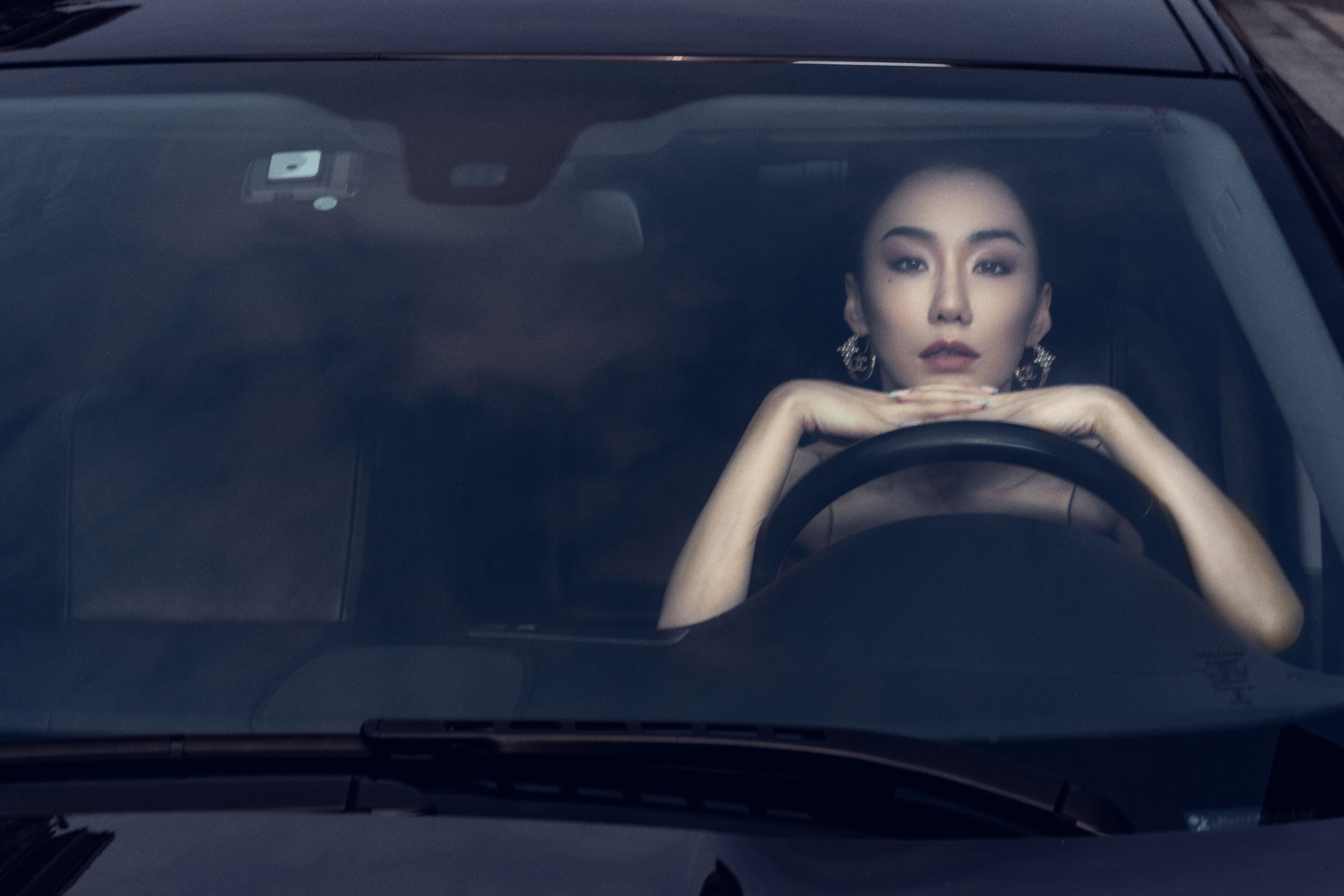 隔着挡风玻璃拍摄的驾驶座女性人像